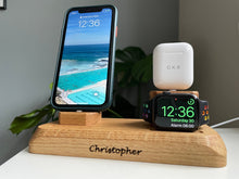 Rectangular oak base with curved corner profiles and chamfered top edge.. Small pedestal with lightning charger in centre for iPhone to sit. Rounded watch tower with flat front fact for watch charger with lightning cable on top for AirPods.